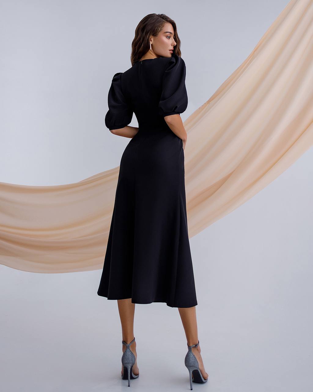 a woman wearing a black dress and heels
