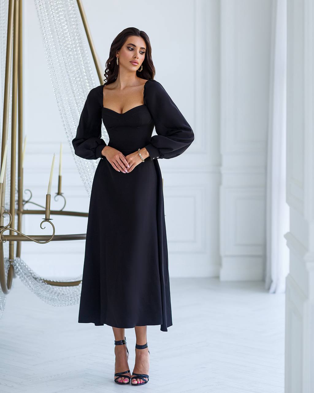 a woman in a black dress standing in a room