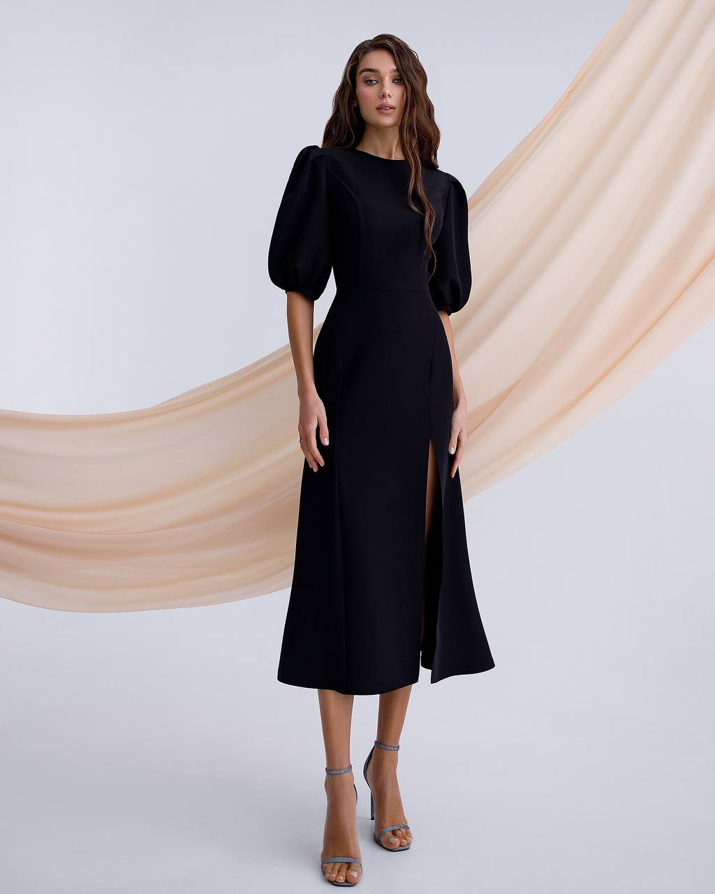 a woman wearing a black dress with a slit