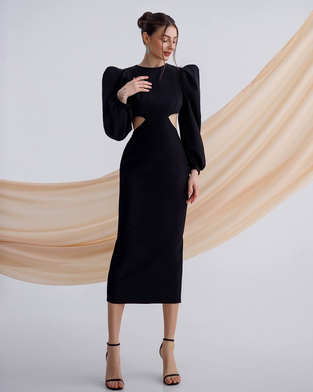 a woman wearing a black dress with a cut out back