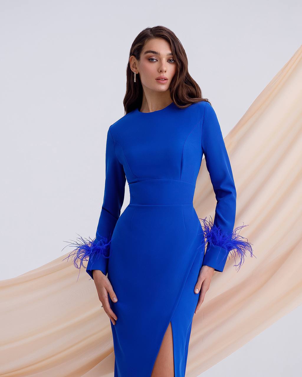 a woman wearing a blue dress with feathers on the side