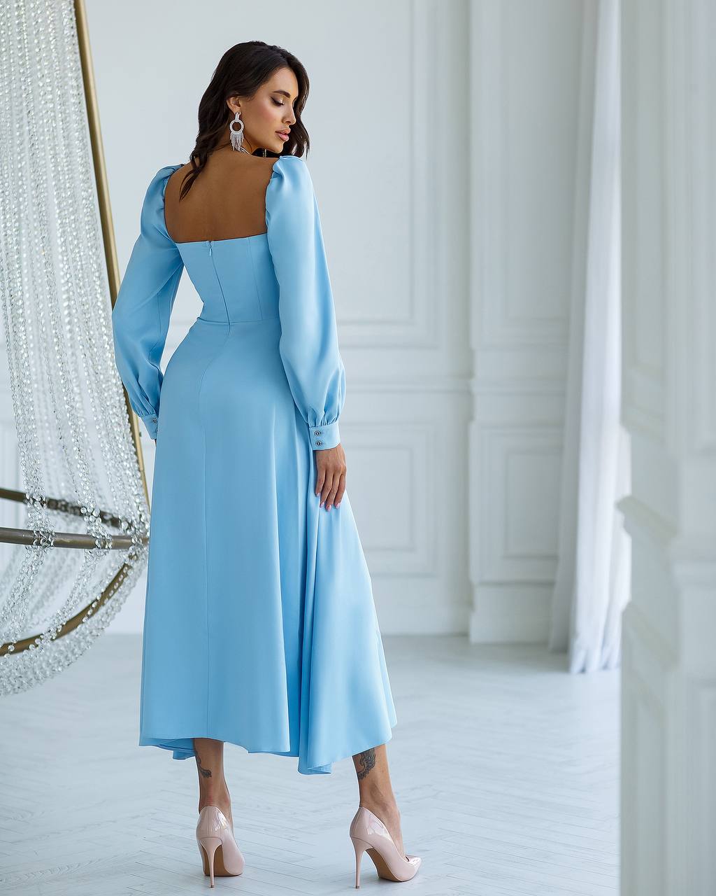 a woman in a blue dress standing in front of a mirror