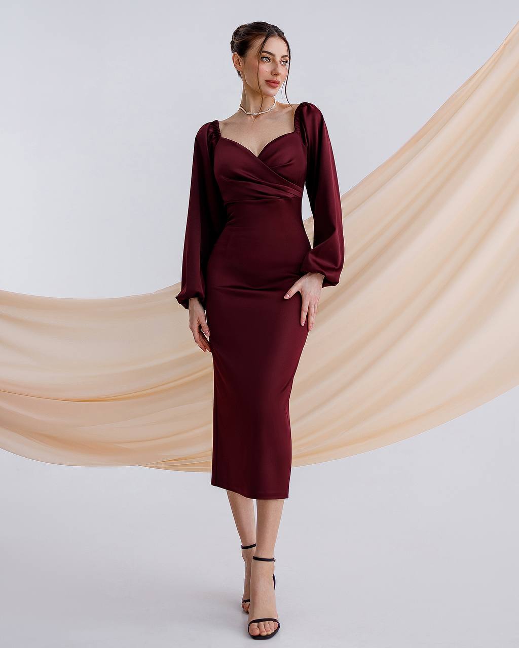 a woman in a burgundy dress posing for a picture
