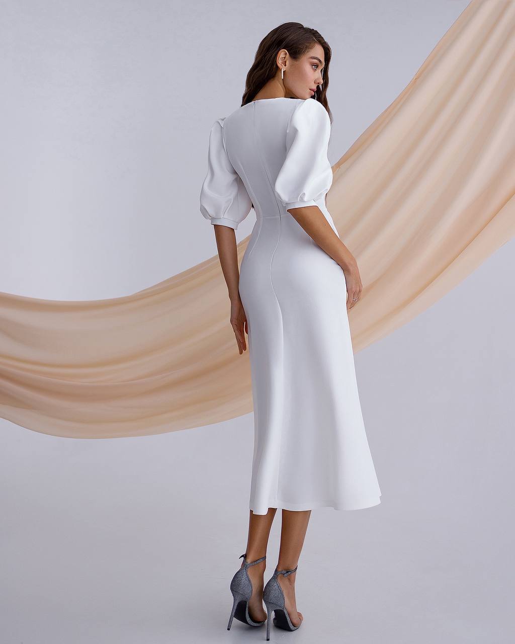 a woman wearing a white dress and heels