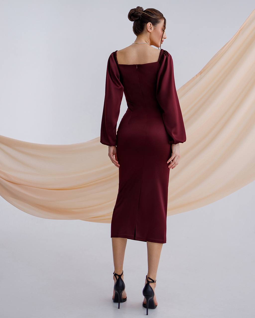 a woman in a maroon dress is standing