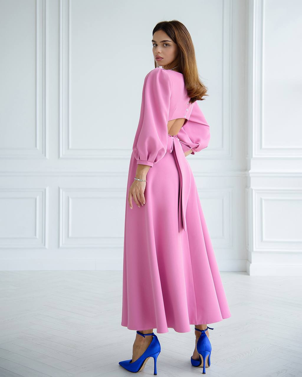 a woman wearing a pink dress and blue heels
