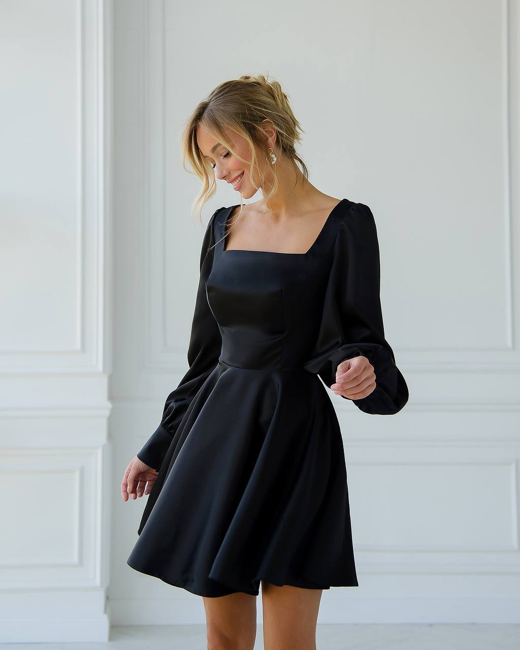 a woman in a black dress is posing for a picture