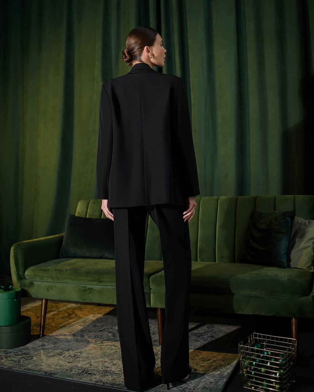 a woman standing in front of a green couch