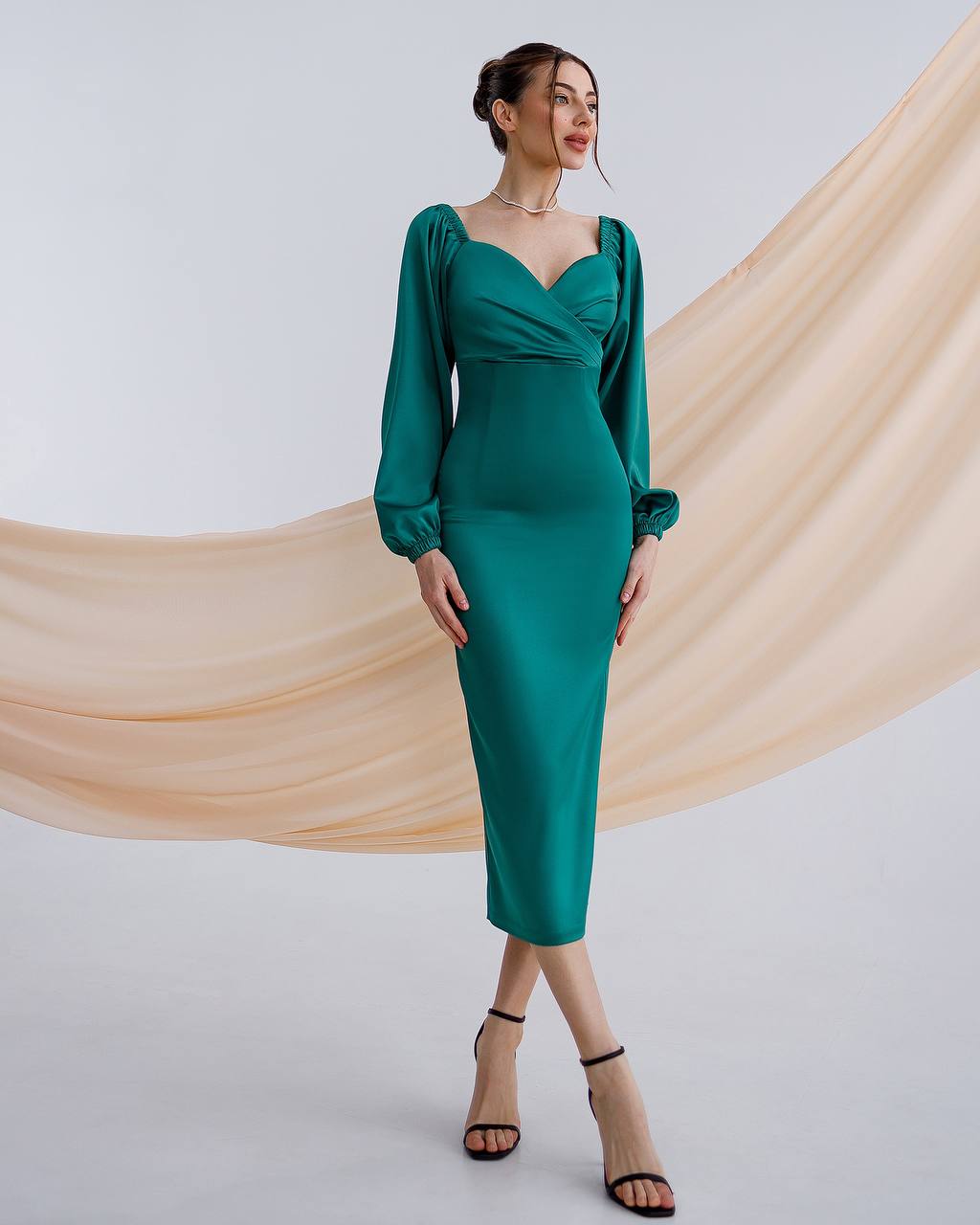 a woman in a green dress posing for a picture