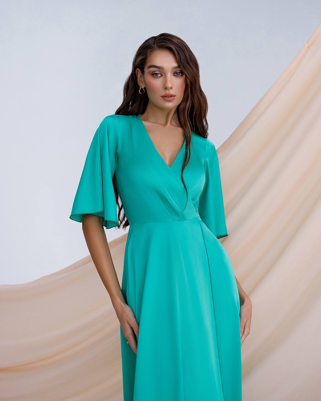 a woman in a green dress posing for a picture