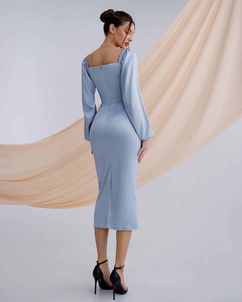 a woman in a blue dress is standing