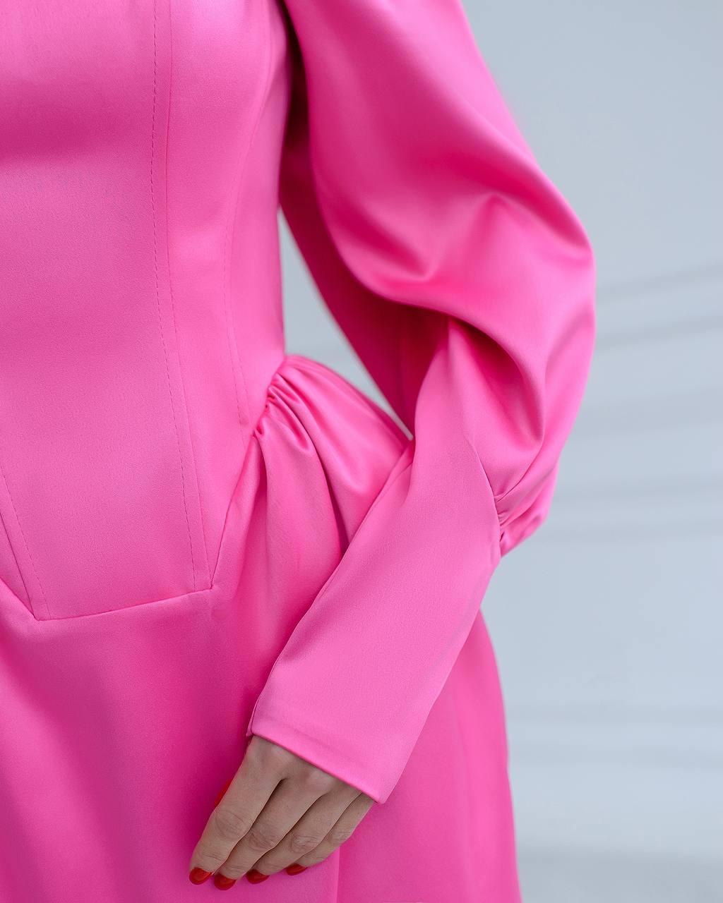 a woman in a pink dress holding her hand on her hip
