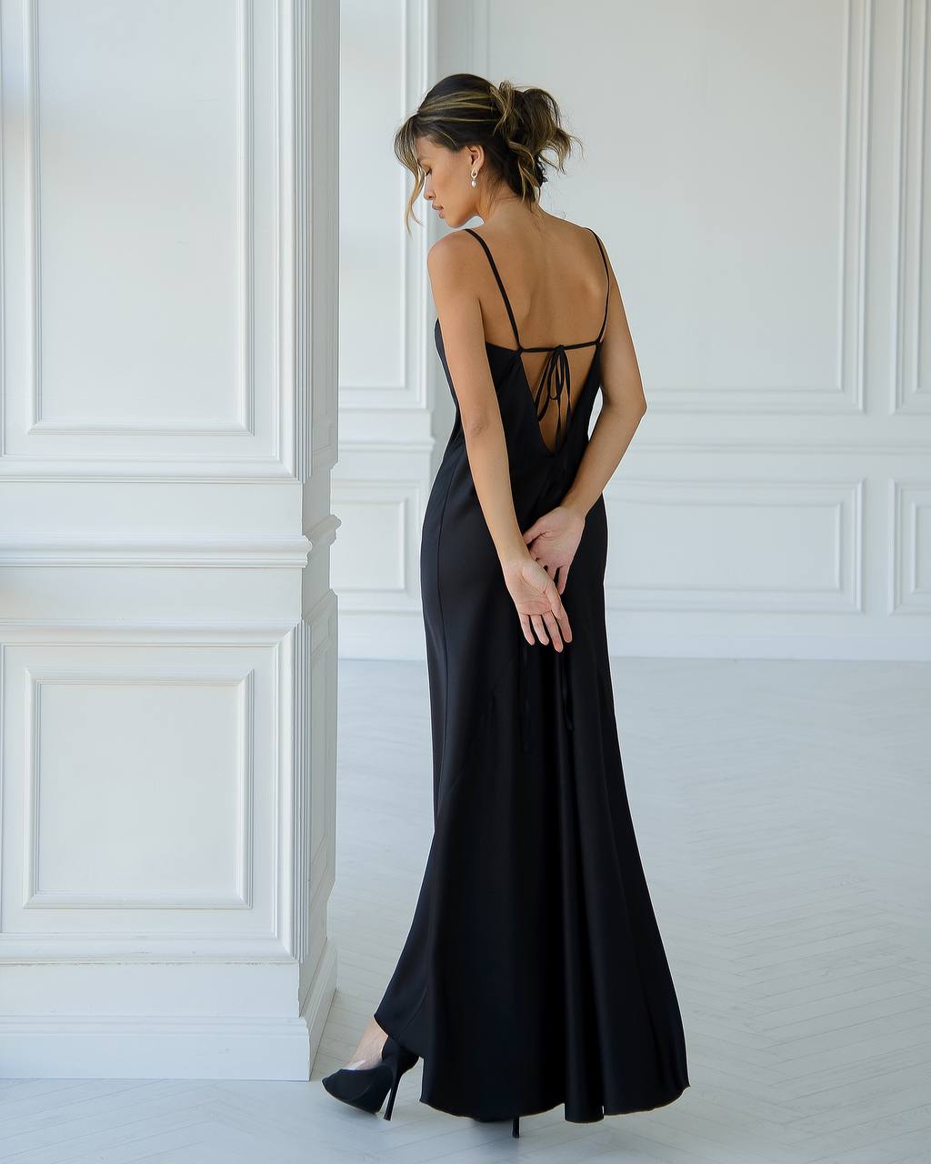 a woman in a black dress standing in a room