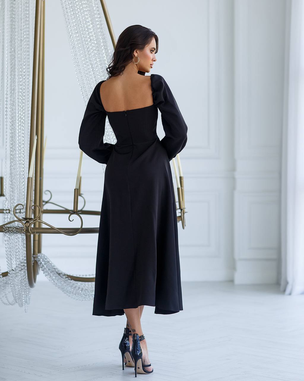 a woman in a black dress standing in a room