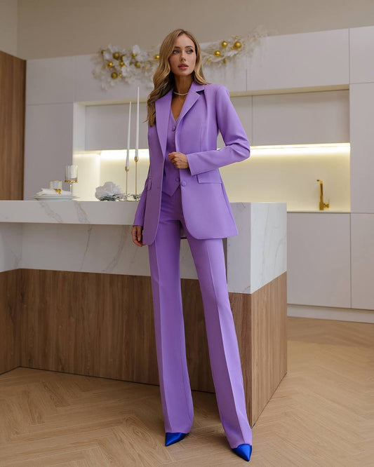 a woman in a purple suit standing next to a counter