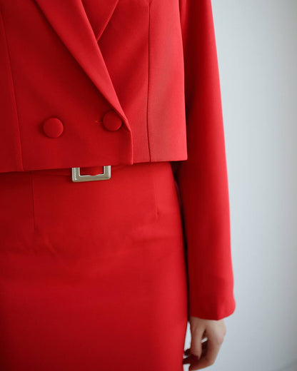 a woman wearing a red suit and a red tie