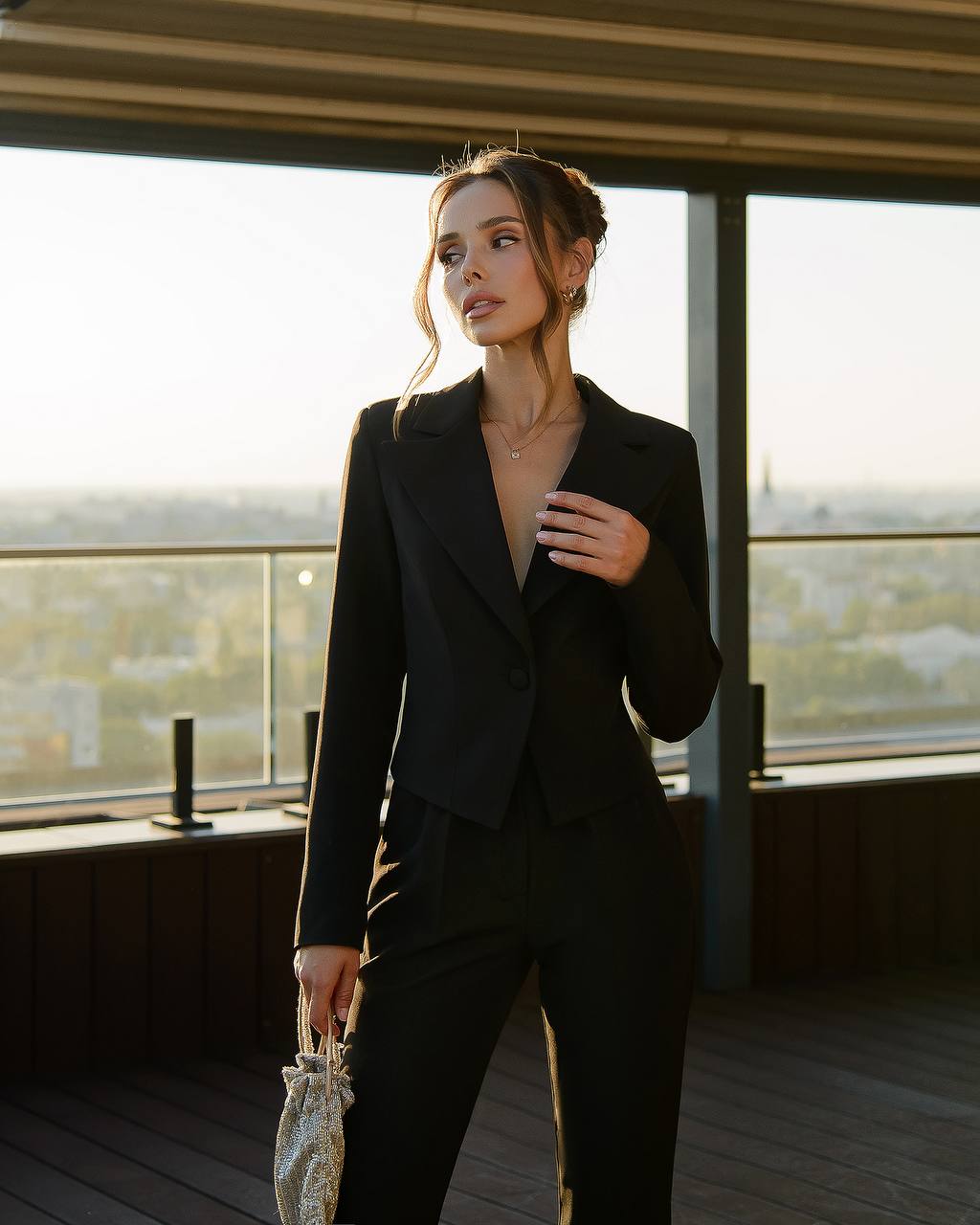 a woman wearing a black suit and holding a purse