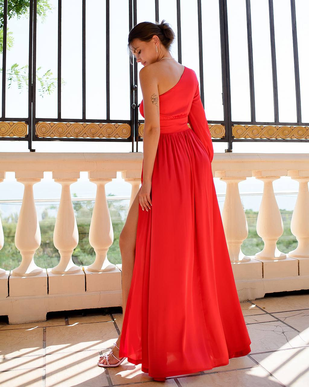 a woman in a long red dress standing on a balcony