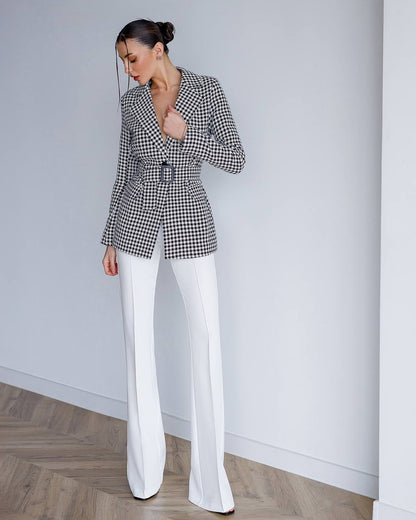 a woman in a black and white jacket and white pants