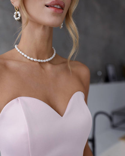 a woman wearing a pearl necklace and earrings