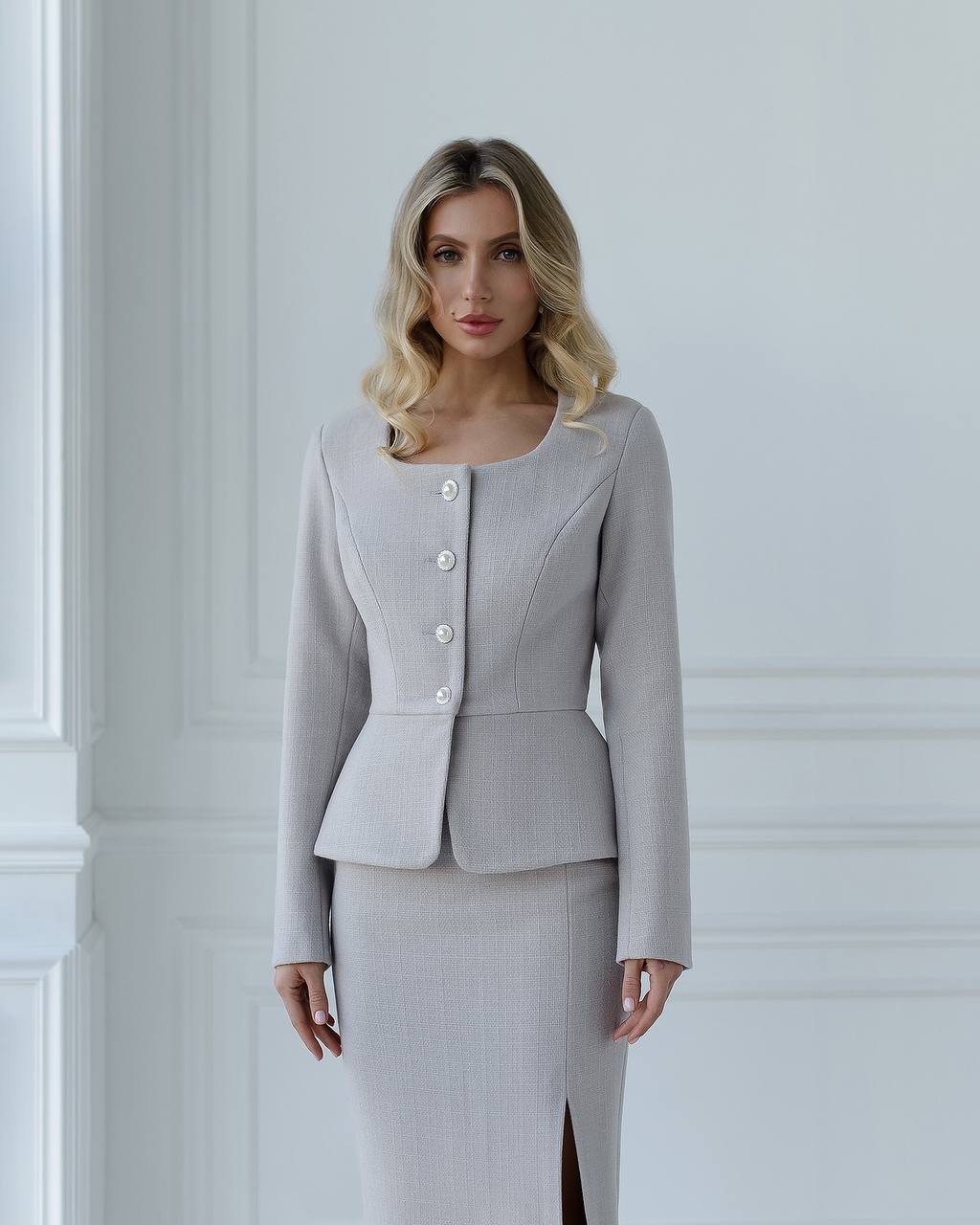 a woman in a grey dress and jacket