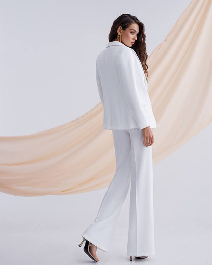 a woman wearing a white suit and heels