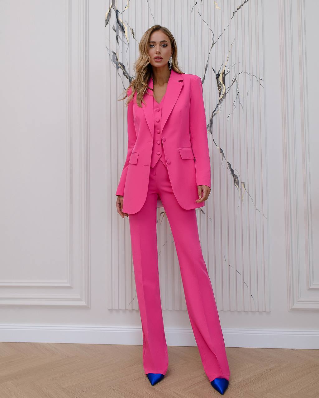 a woman wearing a pink suit and blue shoes