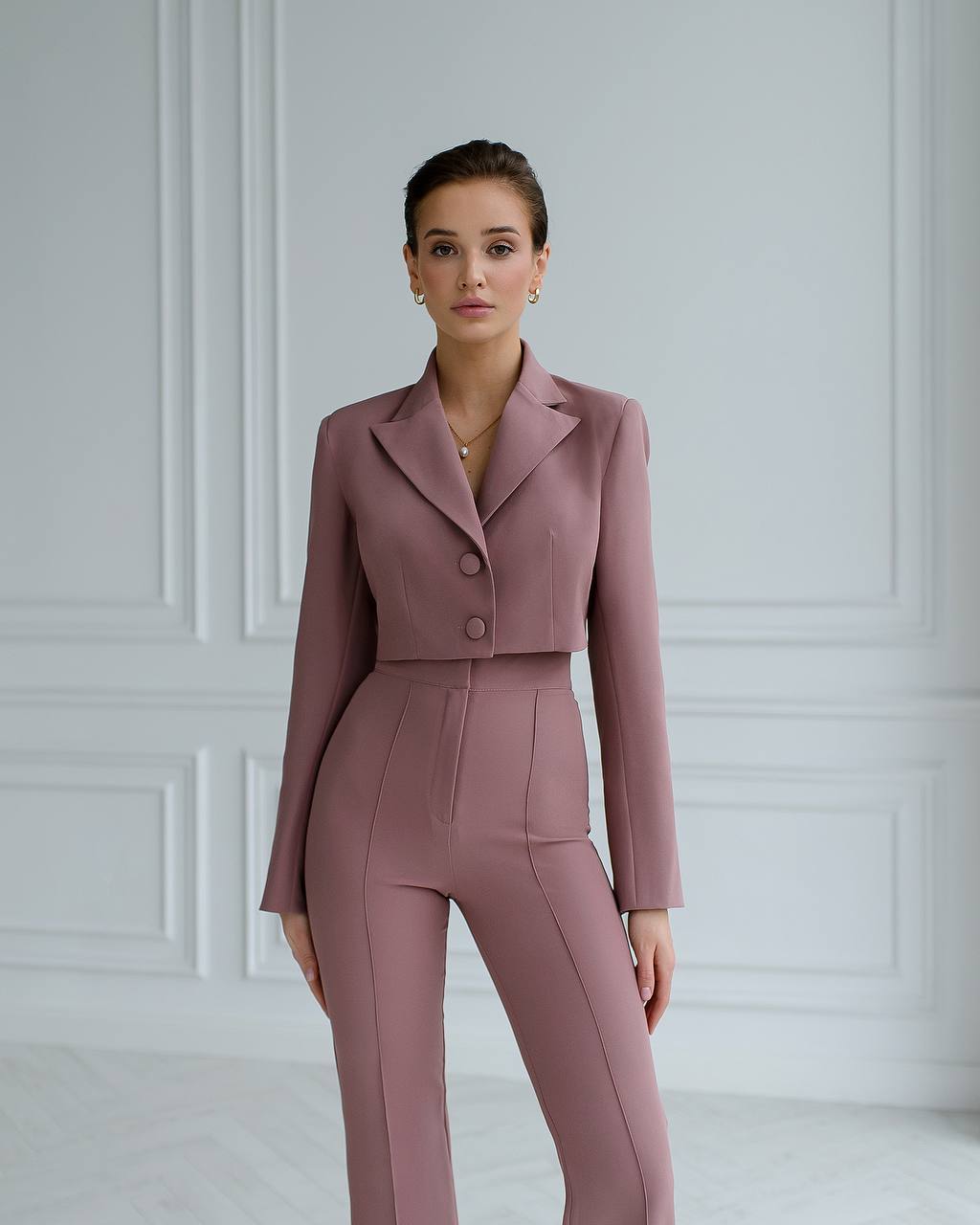 a woman wearing a pink suit and heels