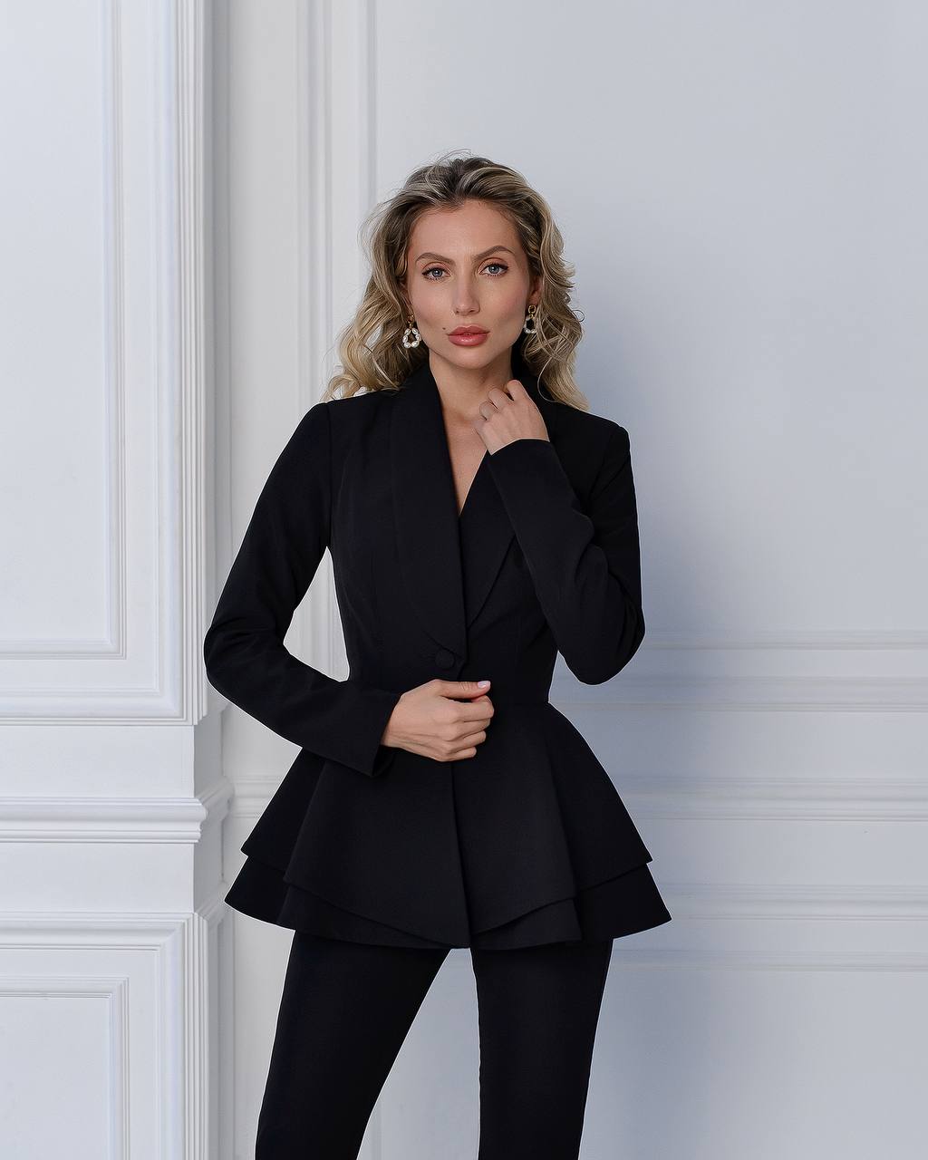 a woman in a black suit posing for a picture