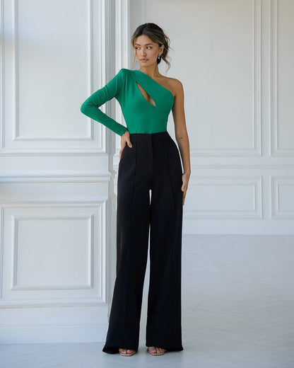 a woman in a green top and black pants