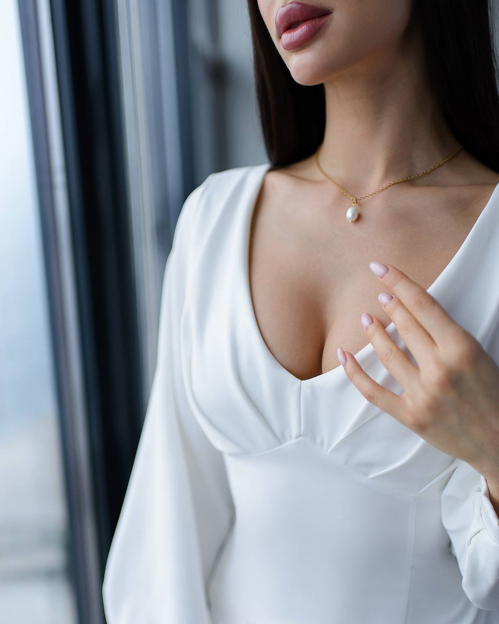 a woman in a white dress with a pearl necklace