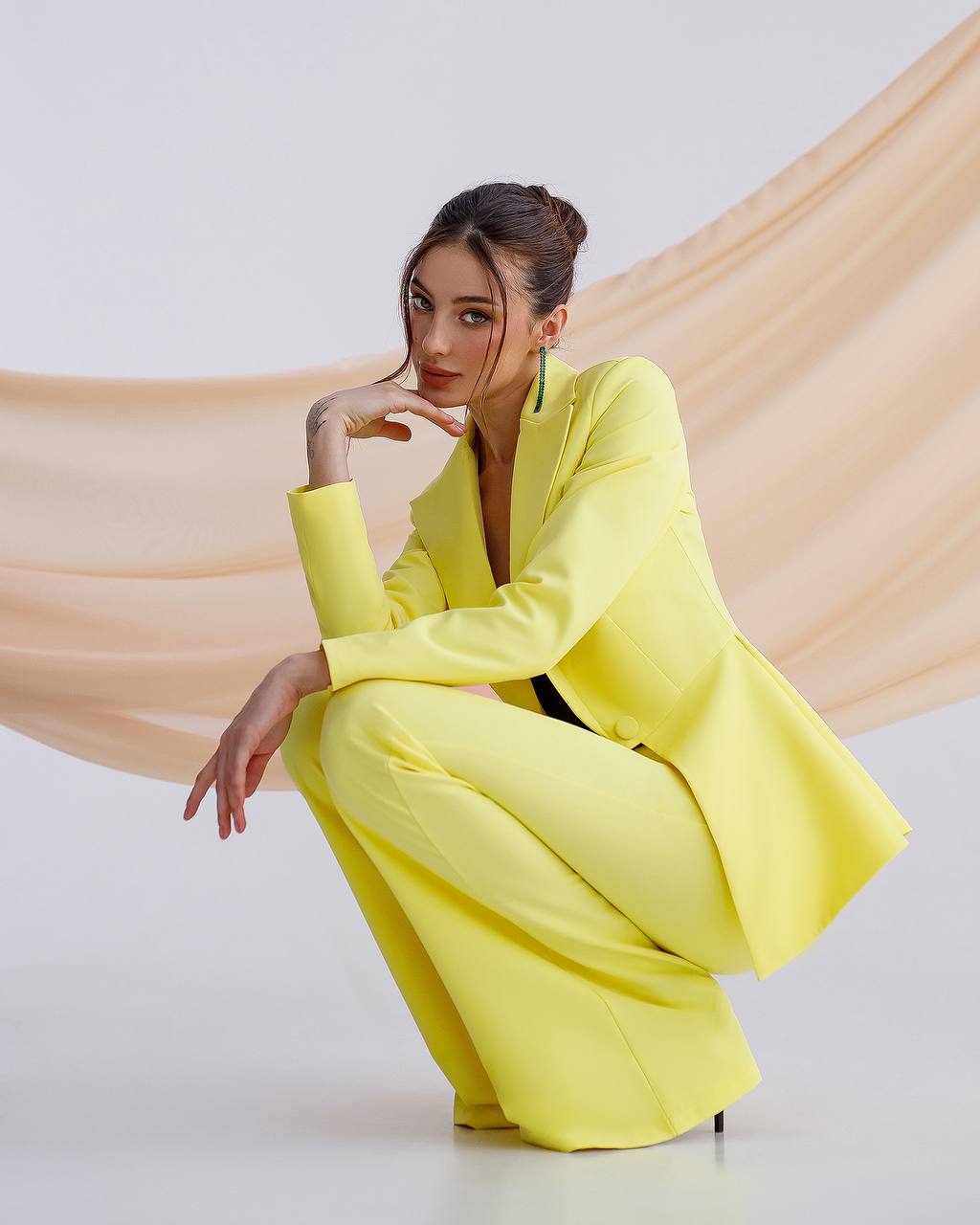 a woman in a yellow suit posing for a picture