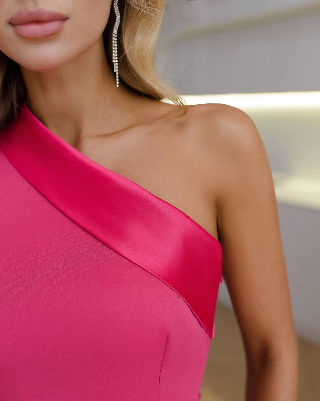 a woman wearing a pink dress and earrings
