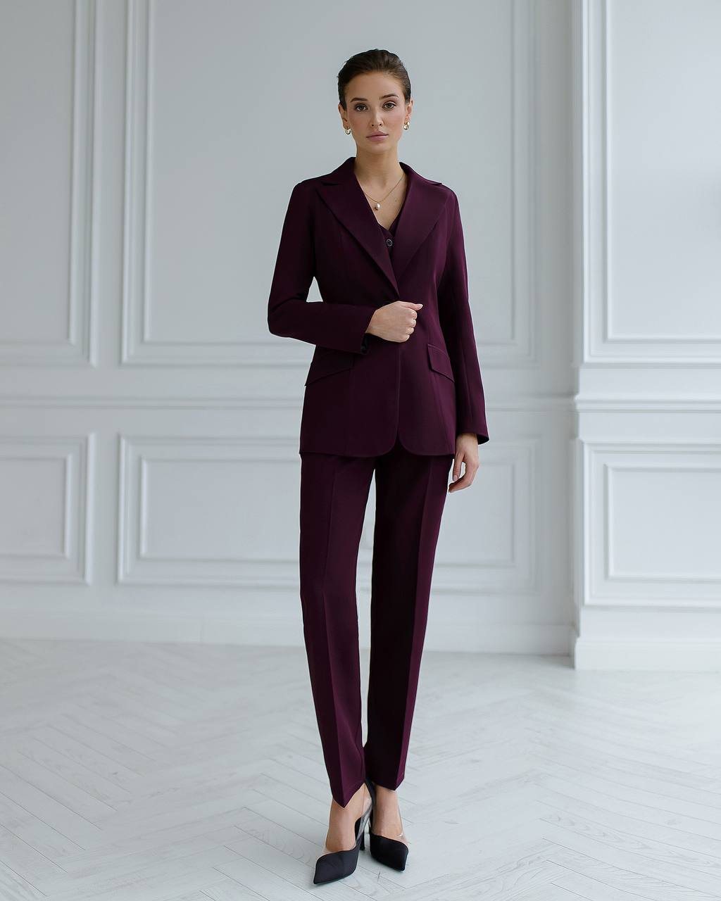a woman wearing a purple suit and black shoes