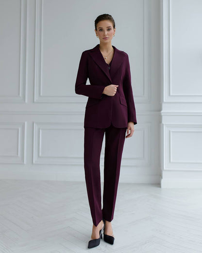 a woman wearing a purple suit and black shoes