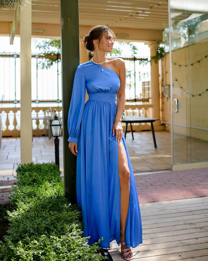 a woman in a blue dress leaning against a pole