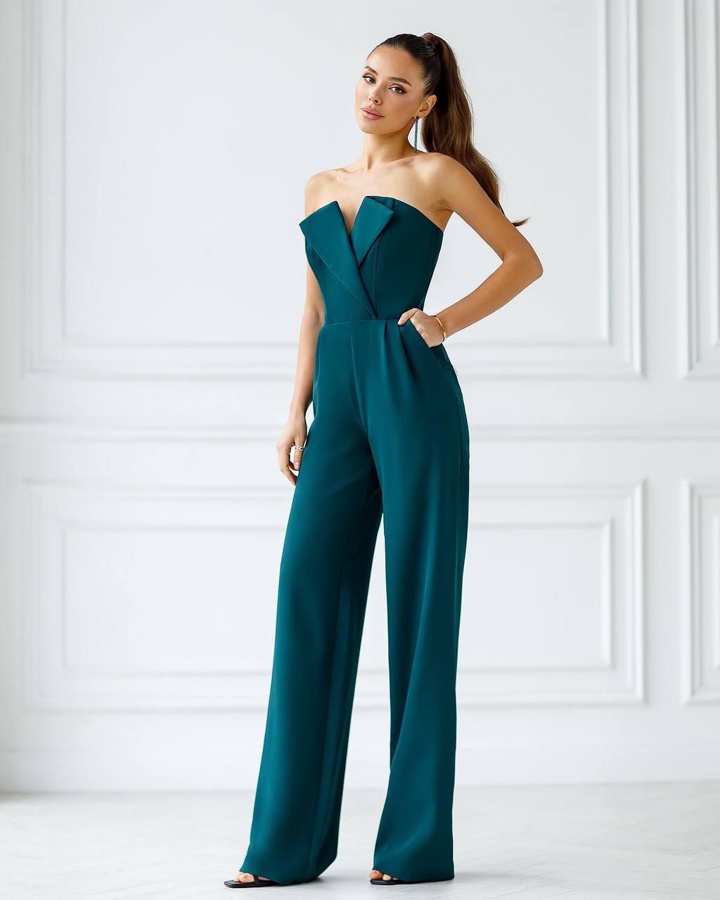 a woman in a green jumpsuit posing for a picture
