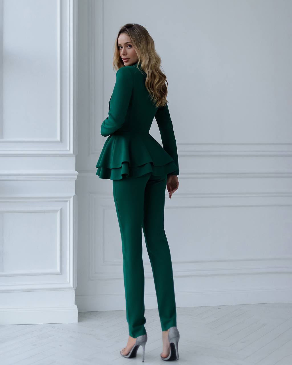 a woman wearing a green suit and high heels