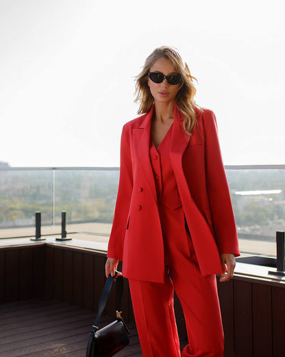 a woman wearing a red suit and sunglasses