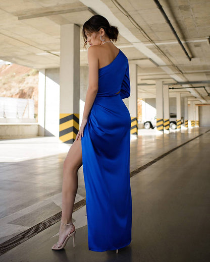 a woman in a blue dress standing in a parking garage