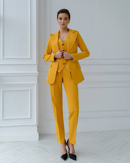 a woman wearing a yellow suit and heels