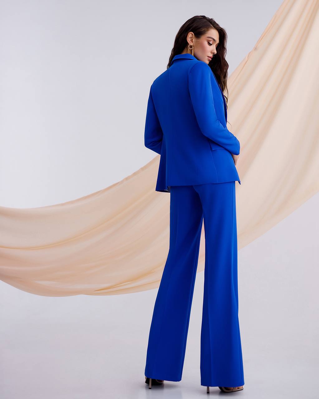 a woman wearing a blue suit and heels