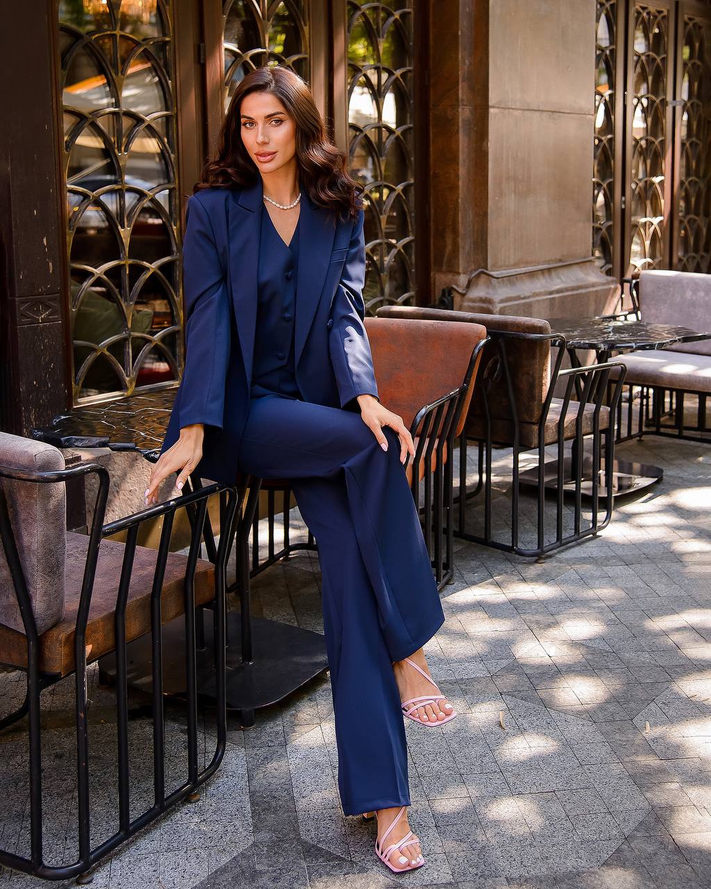 a woman in a blue suit sitting on a bench