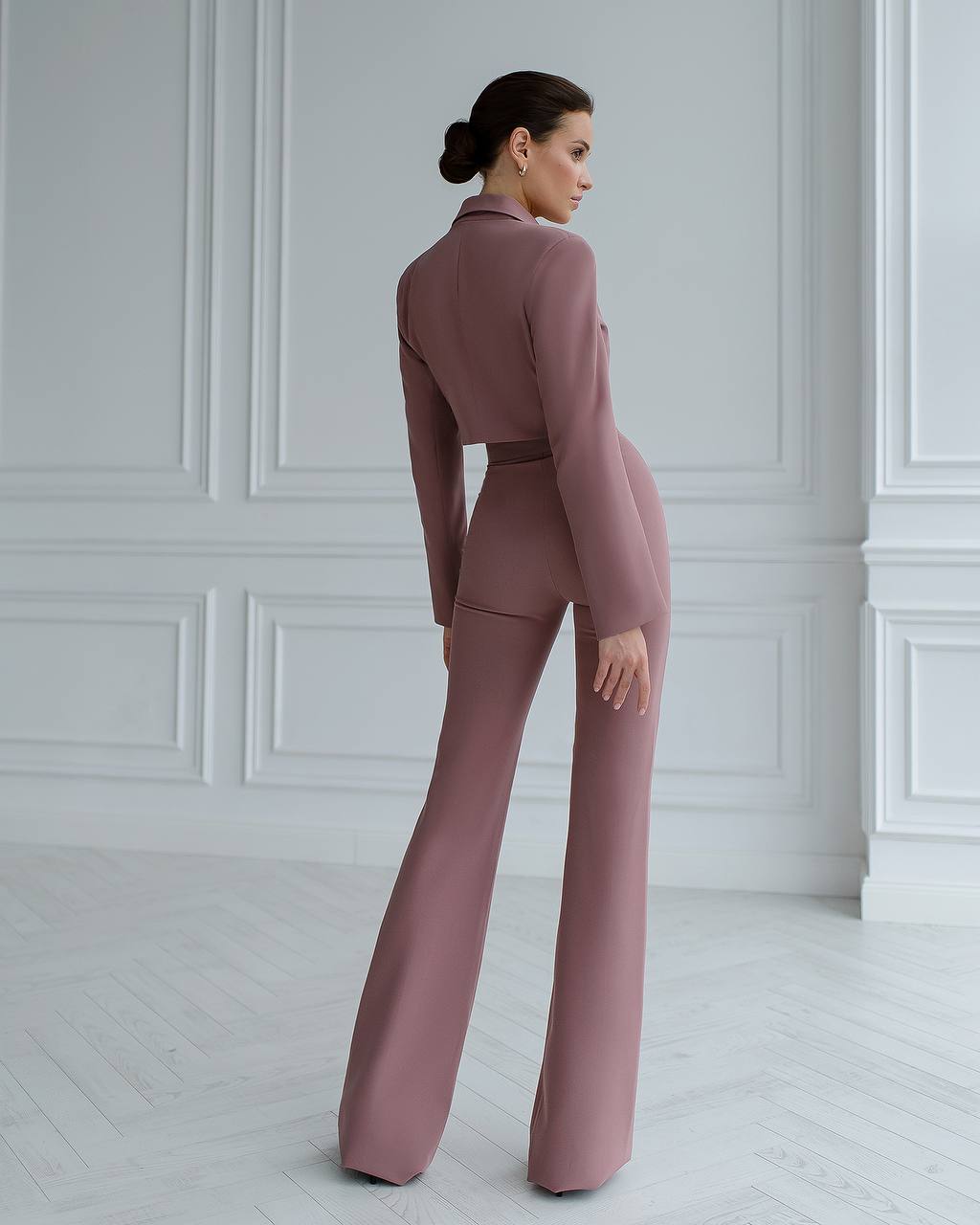 a woman wearing a pink suit and high heels