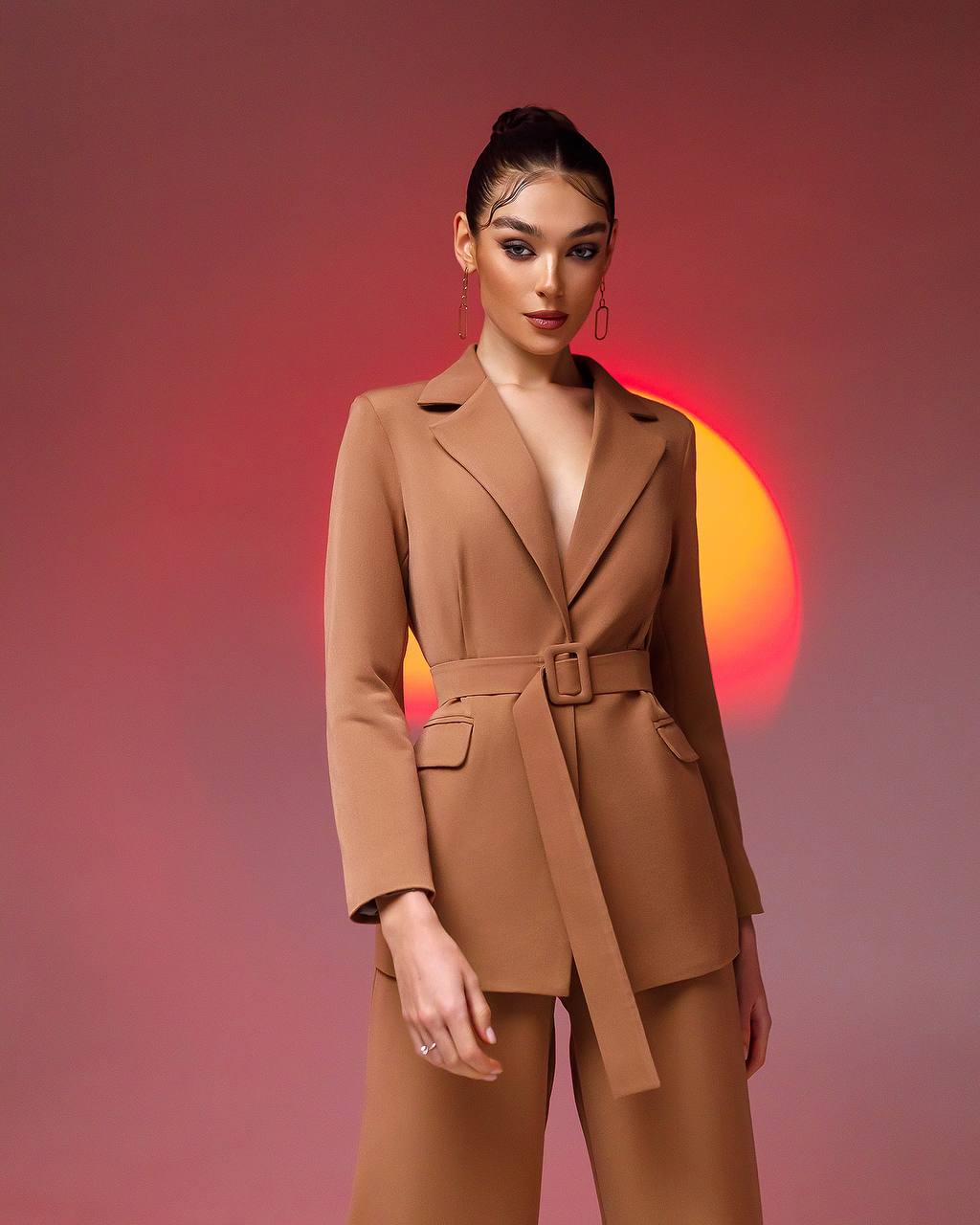 a woman wearing a tan suit and matching heels