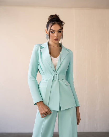 a woman wearing a light blue suit and matching heels