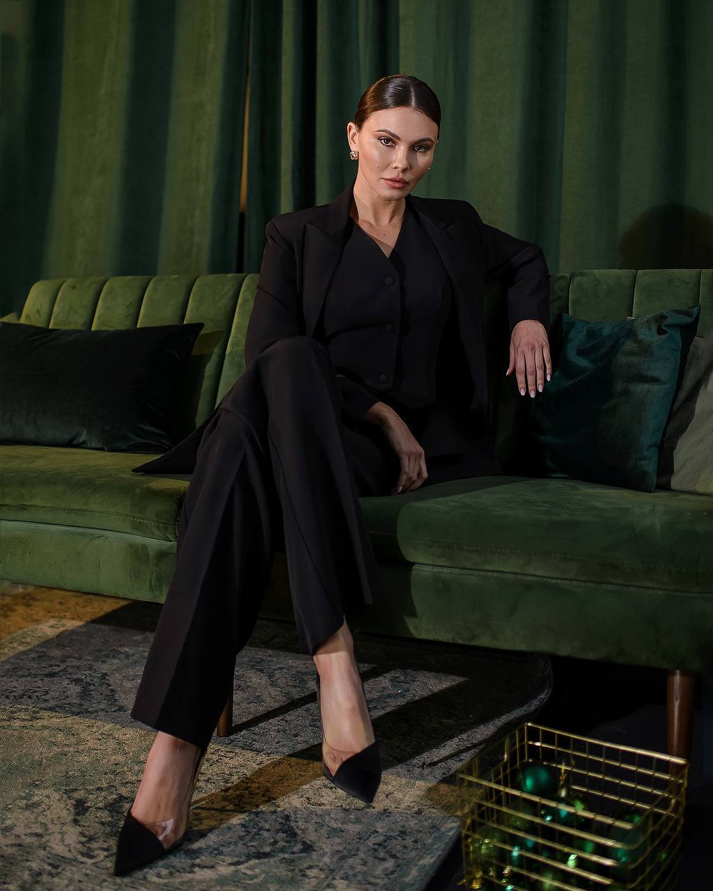 a woman is sitting on a green couch