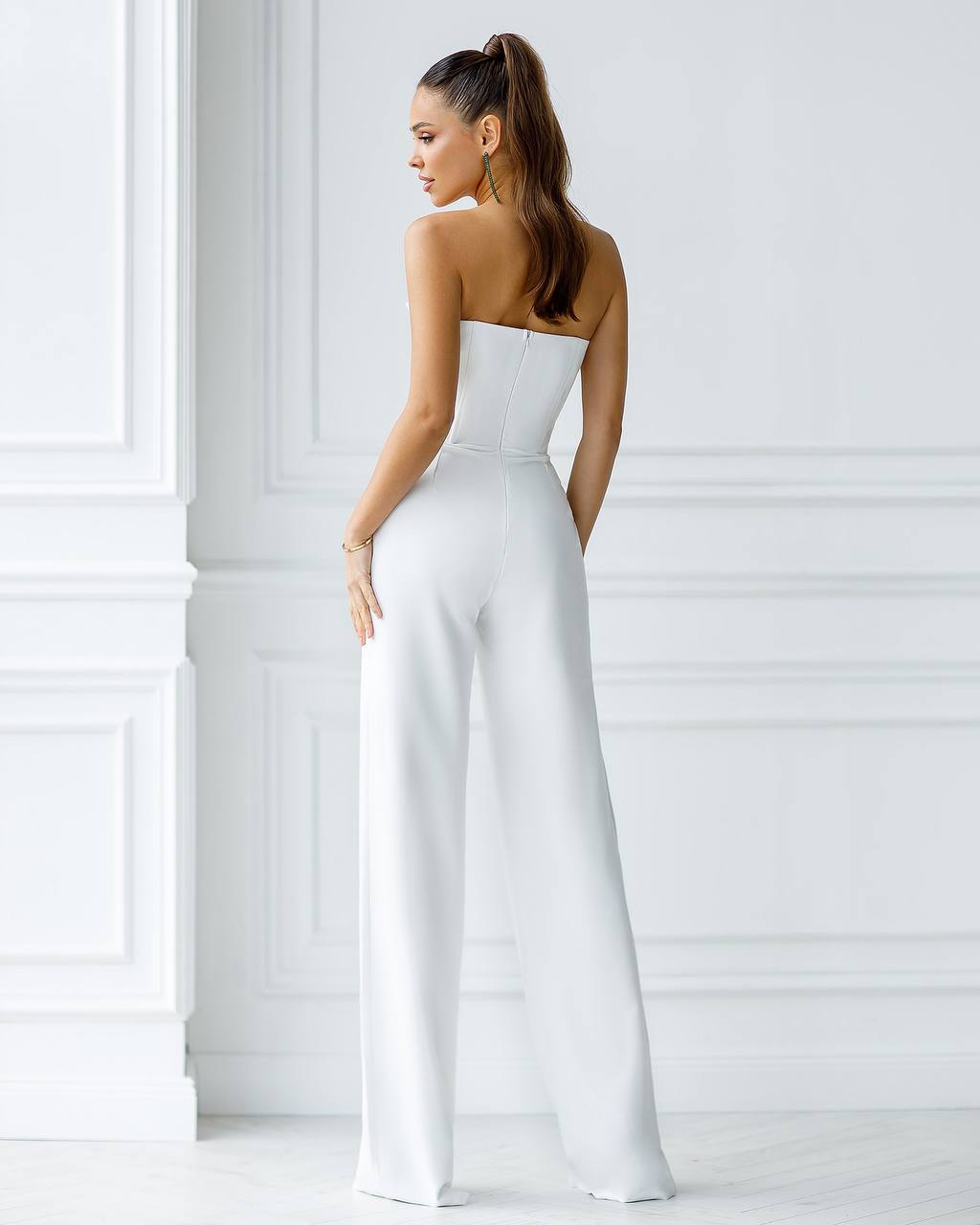 a woman in a white jumpsuit with a backless top