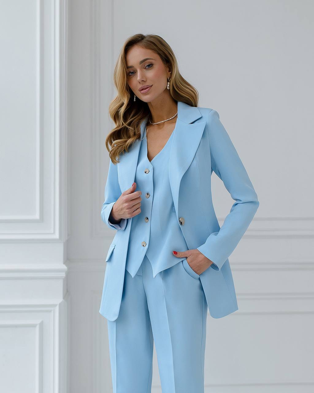 a woman in a light blue suit posing for a picture