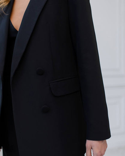 a woman wearing a black blazer and black pants